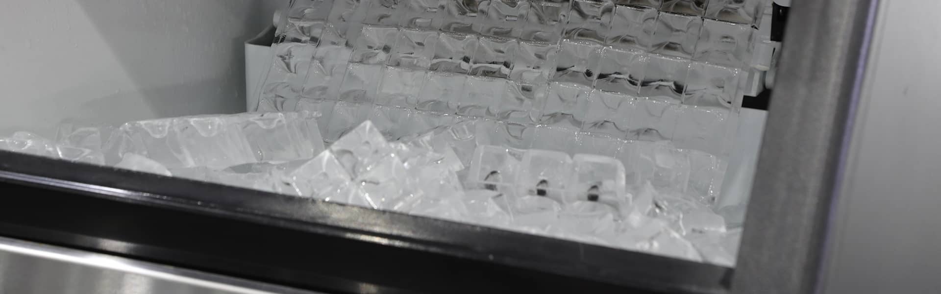 Plan rapproché de cubes de glace dans une machine à glace commerciale